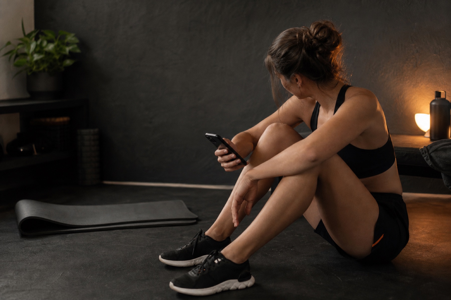 A beginner checking their phone after finishing a short at-home workout